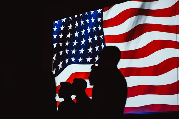 Photo of US citizens in front of an American flag